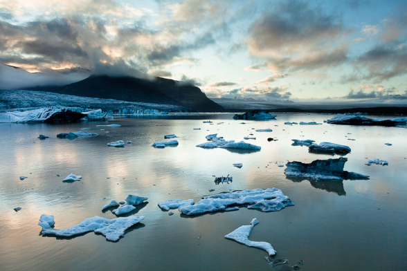 Reflets dorés du soleil couchant sur les morceaux de glace du lac Fjallsarlon, Islande