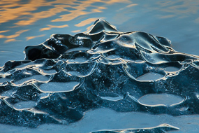 Reflets dorés du soleil couchant sur les morceaux de glace du lac Fjallsarlon, Islande