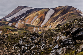 Blocs d'obsidienne devant les massifs ryolithiques du Landmannalaugar, Islande