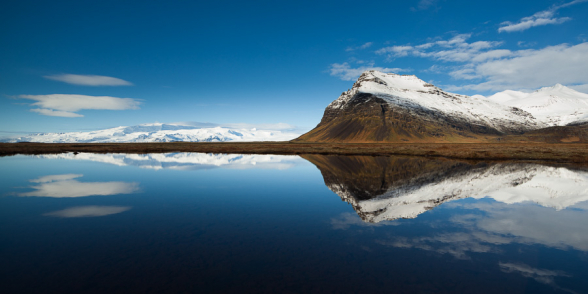 Symétrie du reflet d'une montagne dans une petite mare, à proximité du Jokulsalon, sud de l'Islande