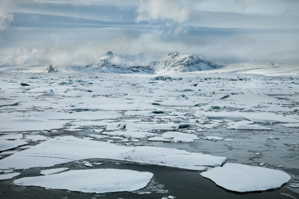 La neige recouvre les plaques de glace et les icebergs qui flottent sur la lagune glaciaire de Jokulsarlon, Islande