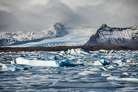 La lagune glaciaire du Jokulsarlon charrie les blocs de glaces, au delà du dépôt morainique, le glacier se déverse dans le Breidarlon, islande