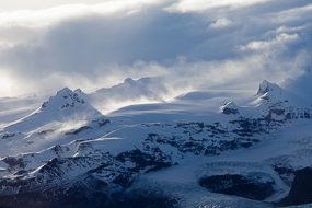 Les nuages courent sur sommets surplombant la langue glaciaire de Kviarjokull, Islande