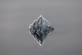 Morceau de glace et son reflet flottant à la surface du Jokulsarlon, Islande