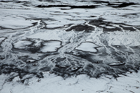 Le torrent Skeidara se transforme en sandur, il charrie les alluvions glaciaires  jusqu'à la mer et forme ce paysage monochrome, le sable noir étant recouvert par la neige, sud de l'Islande