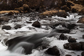 Cascade alimentant un torrent aux abords gelés, sud de l'islande