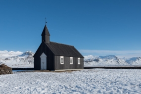 La petite église en bois de Budir au milieu du paysage enneigé de la péninsule de Snæfellsnes