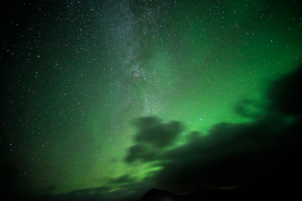 L'ovale auroral nimbe les nuages d'une couleur verte en ce soir d'éclipse lunaire, Islande