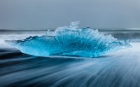 Iceberg errodé par les vagues sur la plage de sable noir à proximité de Jolulsarlon, Islande